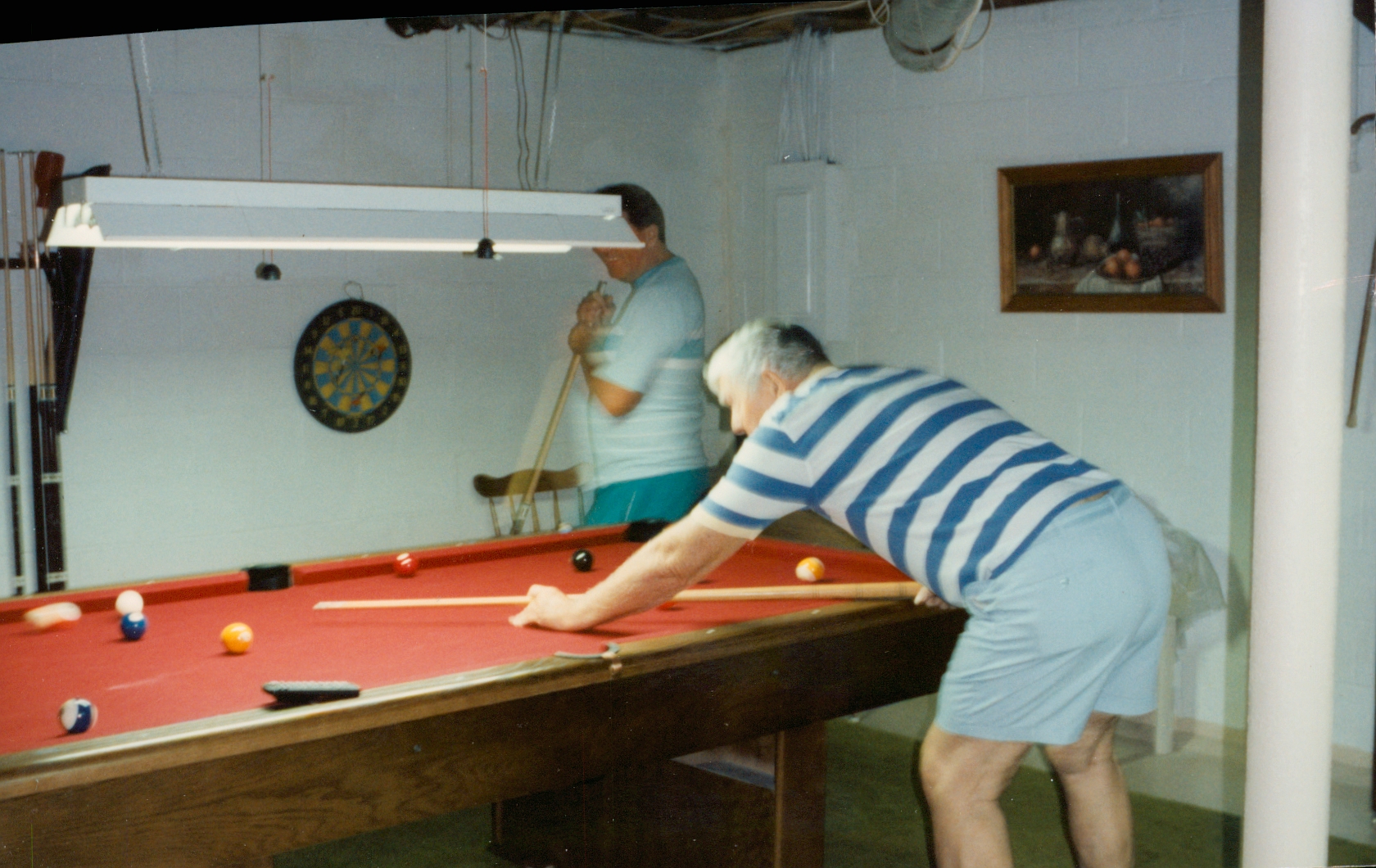 Charles Leo McGarvey playing pool with his son Fred in Moody, Alabama, during the 1980s